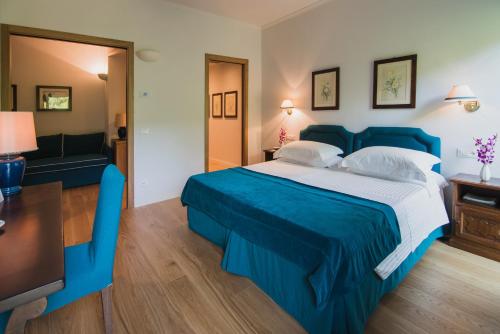 a hotel room with a blue bed and a couch at Gallia Palace Hotel - Relais & Châteaux in Punta Ala