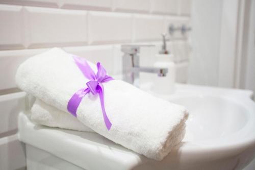 a towel with a purple ribbon sitting on top of a toilet at Apartament EC1 Łódź Fabryczna in Łódź