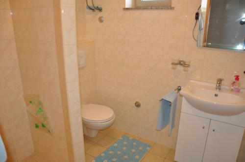 a bathroom with a toilet and a sink at Apartments Alicia Lopar-50m vom Strand in Lopar