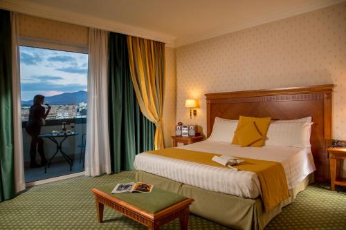 a hotel room with a bed and a woman taking a picture at Best Western Hotel Viterbo in Viterbo