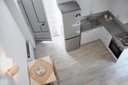 Una pequeña cocina con una mesa y un refrigerador. en Angolo vista mare, en Savelletri di Fasano
