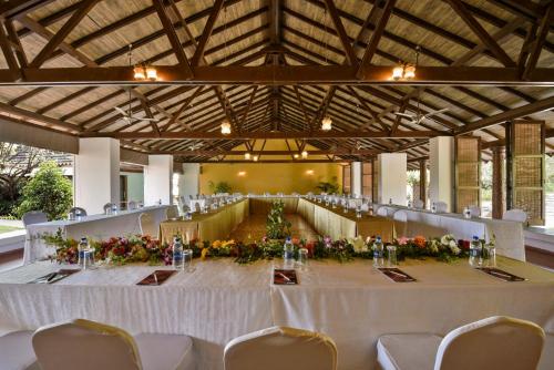 a large banquet hall with a long table with flowers at The Fern Samali Resort in Dapoli