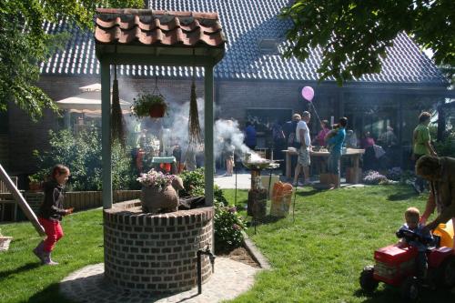 a group of people in a backyard with a grill at B&B Artiriacumhoeve in Zedelgem