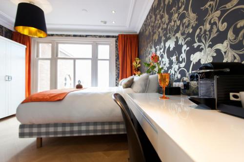 a bedroom with a large bed and a large window at Amsterdam Canal Hotel in Amsterdam
