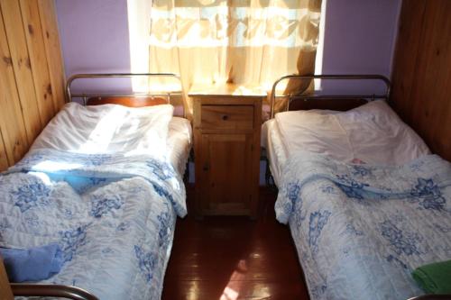 a room with two beds and a window at Ecohouse Svaneti in Mestia