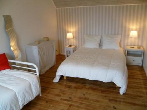 une chambre d'hôtel avec deux lits et deux lampes dans l'établissement Chez Jeanne, à Plouguerneau