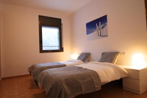 two beds in a room with a window at Pont de Toneta 5,3 Ransol, Zona Grandvalira in Ransol