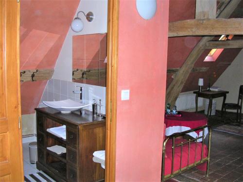 uma casa de banho com um lavatório e um espelho em la Maison des Aubées em Rémalard