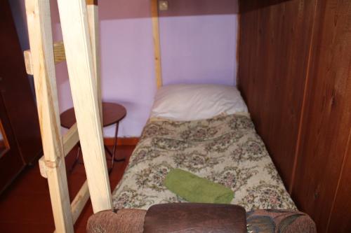 a small bed in a small room with a bunk bed at Ecohouse Svaneti in Mestia