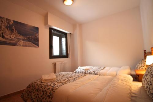 a bedroom with two beds and a window at Pont de Toneta 6,2 Ransol, Zona Grandvalira in Ransol