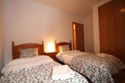 1 dormitorio con 2 camas y lámpara en Pont de Toneta 6,2 Ransol, Zona Grandvalira en Ransol