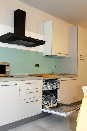 a kitchen with white cabinets and a dishwasher at Il Convento Case Vacanze in Rapallo