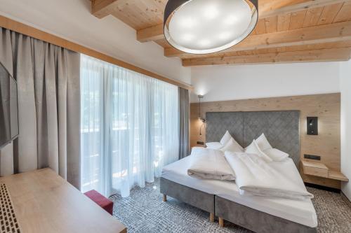 a bedroom with a bed and a large window at Hotel Grauer Bär in Sölden