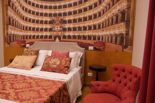 een bed en een stoel in een kamer met een muurschildering bij Spaccanapoli B&B City Soul in Napels