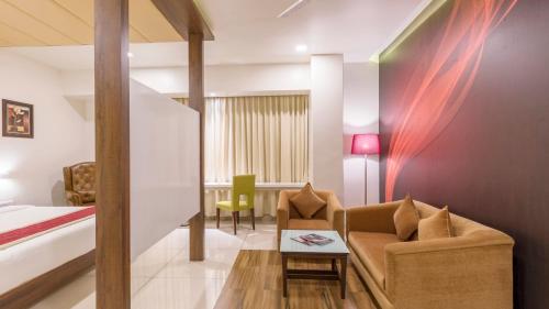a room with a bed and a couch and a table at Sai International Hotel in Dāvangere