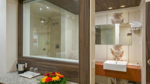 a bathroom with a sink and a mirror at Sai International Hotel in Dāvangere