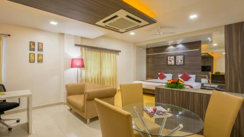 a hotel room with a bed and a dining room at Sai International Hotel in Dāvangere