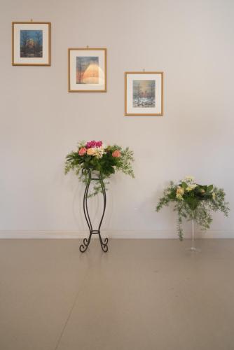 two flowers on a stand in front of a wall at Casa Vacanza Dal Cavaliere in Montesarchio