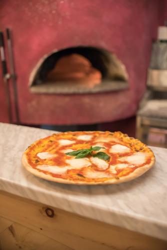 a pizza sitting on a table in front of an oven at Hotel Astoria in Livigno