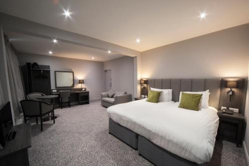a hotel room with a large bed and a chair at Hawkstone Park in Wem