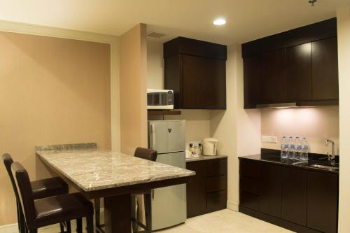 a kitchen with a counter top and a refrigerator at I Hotel Batam in Nagoya