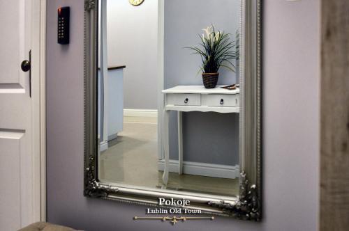 a mirror on a door with a table and a plant at Lublin Old Town Rooms in Lublin