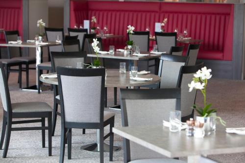 a restaurant with tables and chairs with flowers on them at Hawkstone Park in Wem