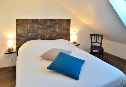 Un dormitorio con una cama con una almohada azul. en BUGEAUD #4 - Appartement chaleureux - 4 personnes, en Brive-la-Gaillarde