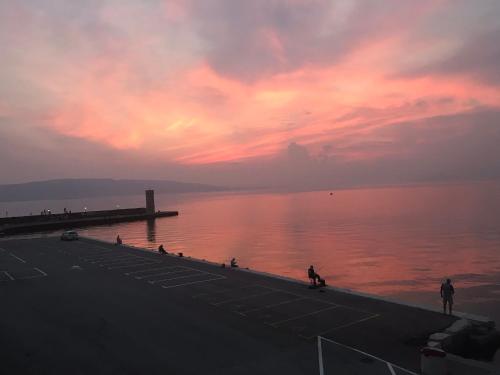 a sunset over a body of water with people on a dock at Hotel Art in Senj