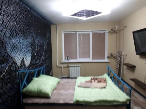 a bedroom with a bed with a painting on the wall at Апартаменты двухкомнатные in Kansk