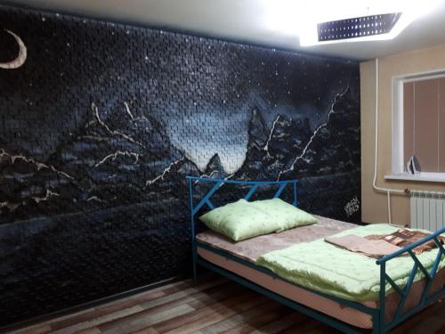 ein Schlafzimmer mit einer Wand mit einem Gemälde darauf in der Unterkunft Апартаменты двухкомнатные in Kansk