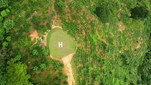 an aerial view of a green field in the middle of a forest at Simpson's Forest - Luxury Boutique Resort & Spa - Kandy in Kandy