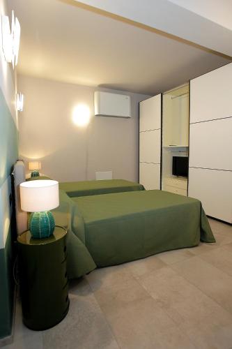 a bedroom with two green beds and a lamp at Il Convento Case Vacanze in Rapallo