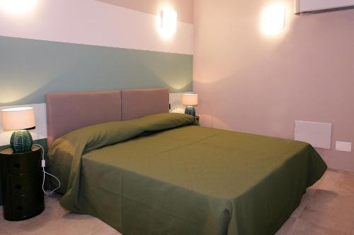 a bedroom with a green bed with two lamps at Il Convento Case Vacanze in Rapallo