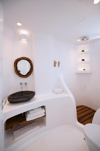 a white bathroom with a sink and a mirror at Potami Home by Rocks Estates in Naousa