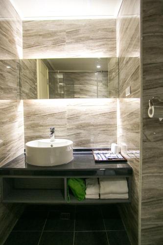 a bathroom with a sink and a mirror at Huang Shin Business Hotel-Shang An in Taichung