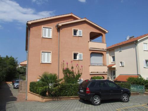 a black car parked in front of a building at Apartman Helen in Malinska