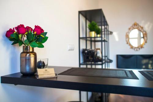 a table with a vase of roses on it at Apartament LOFT Industrial EC1 in Łódź