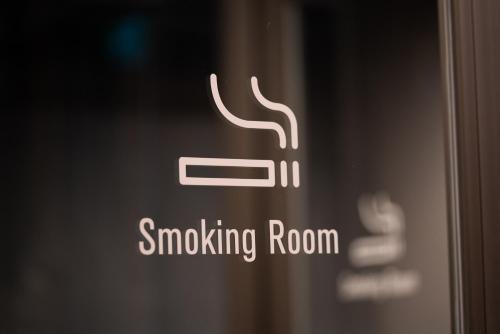 a close up of a smoking room sign on a door at global cabin Yokohama Chinatown in Yokohama