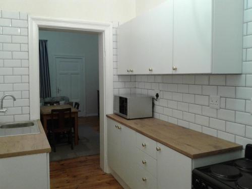 a kitchen with white cabinets and a counter top at Jetty Self-Catering in Swakopmund