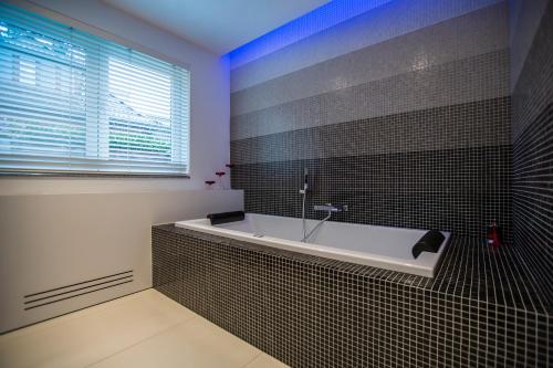 a bathroom with a bath tub and a window at Wellness Hasselt B&B in Hasselt
