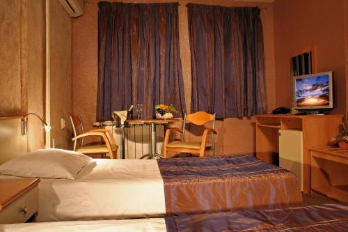 a hotel room with a bed and a table at Hotel Brod - Free Parking in Sofia