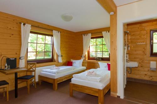 a bedroom with two beds and a desk and a sink at Hotel & Restaurant Wilder Eber in Eberswalde-Finow