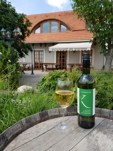 una bottiglia di vino bianco seduta accanto a un bicchiere di Koczor Winery & Guesthouse a Balatonfüred
