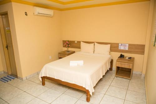a hotel room with a bed and a desk at Hotel Diniz in Barra do Corda