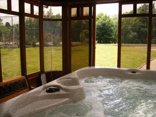 bañera en una habitación con ventana en Camillaun Lodge with Lough Corrib Boat Hire, en Oughterard