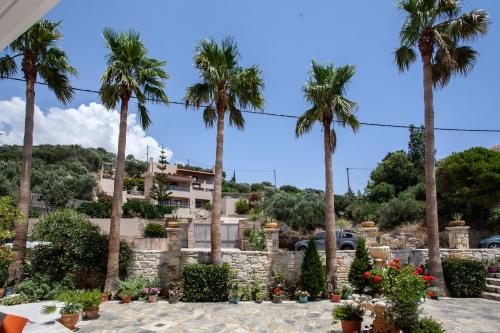 a villa with palm trees and a building at Porto Plakias & Spa in Plakias