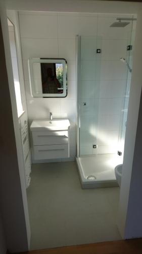 a white bathroom with a sink and a shower at Pension Bergblick in Ruhpolding