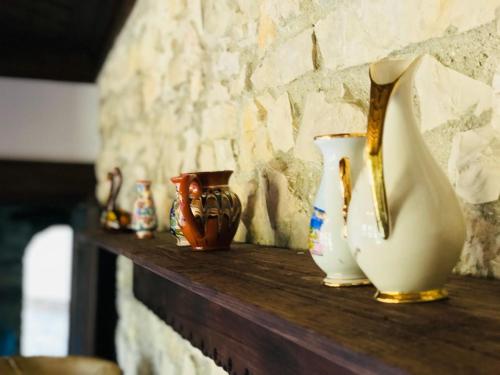 a shelf with vases on top of a stone wall at Hani i Xheblatit in Berat