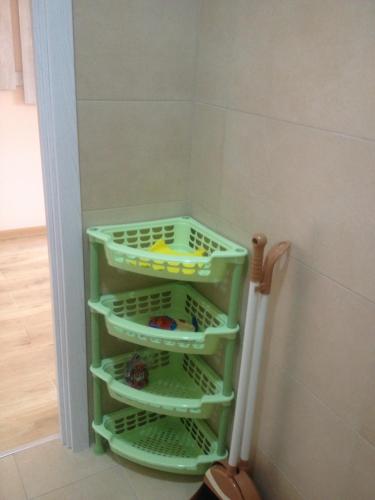 a green shelf in a corner of a bathroom at Nodari in Batumi